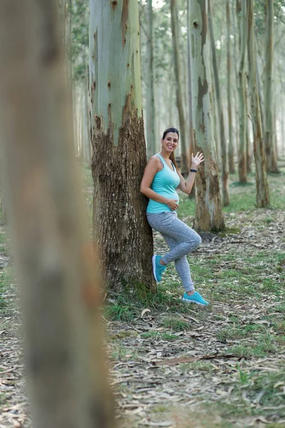 スポーティな妊娠中の女性が手を振っています 自然の中の屋外健康フィットネスのワークアウト中に休憩の女性選手 休憩を取って健康な妊婦 — ストック写真