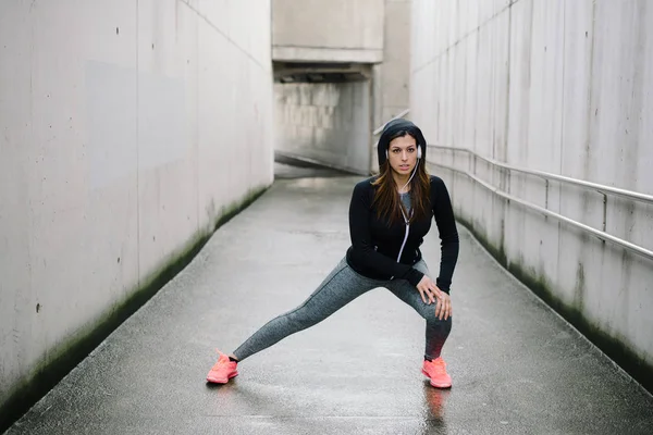 スポーティな女性のストレッチとウォーミング アップ都市フィットネス トレーニングを実行するための足 スポーツと健康的なライフ スタイルのコンセプト 外運動女性アスリート — ストック写真