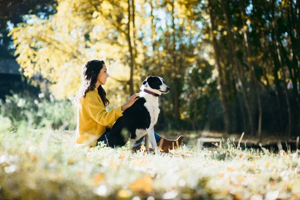 愛犬を自然の中の美しい秋の一日を楽しむカジュアルな女性 — ストック写真