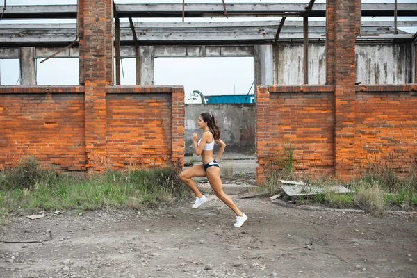 Νεαρή Αθλήτρια Τρέχει Στα Ερείπια Του Παλιού Βιομηχανικού Σπορ Τακτοποίηση — Φωτογραφία Αρχείου
