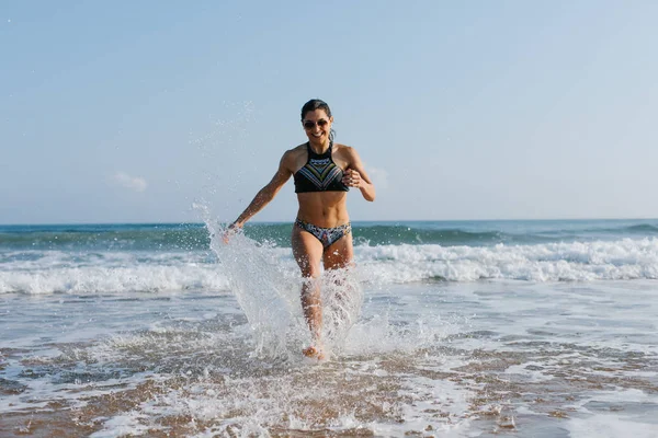 Vrouw genieten van de zomer opleiding op het strand — Stockfoto