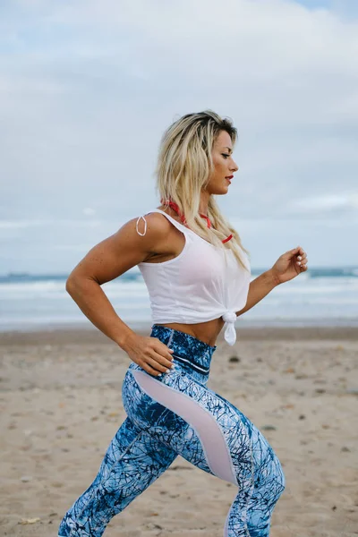 Mulher fitness correndo na praia — Fotografia de Stock