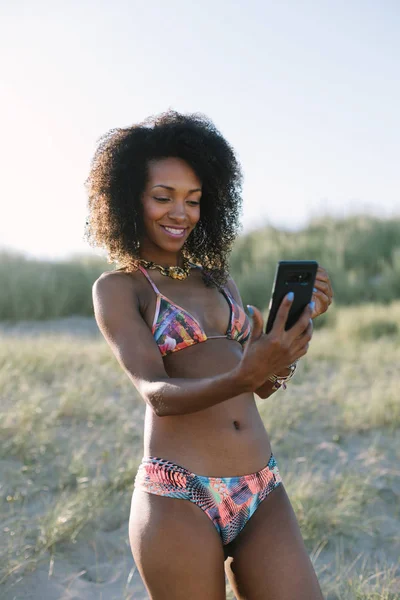 Mladý afro vlasy žena přičemž selfie na pláži — Stock fotografie