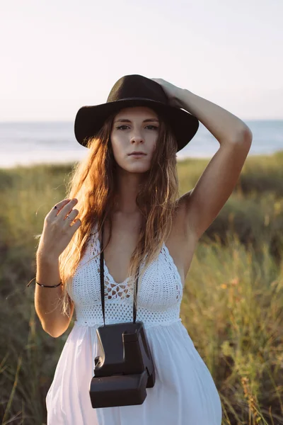 Hipster woman taking photos with an old instant analog camera in — Stock Photo, Image