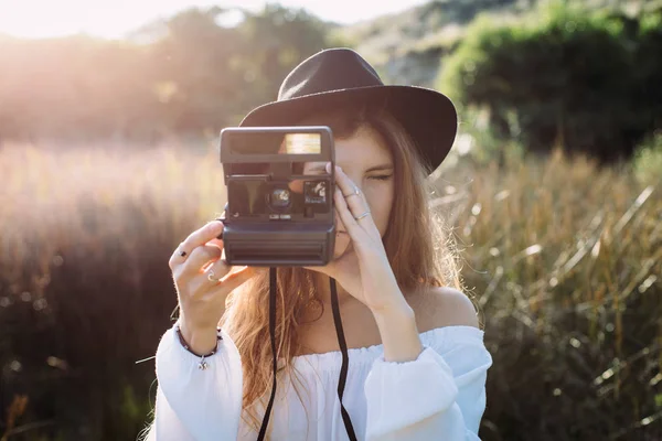 Hipster mujer tomando fotos con una vieja cámara analógica instantánea en —  Fotos de Stock