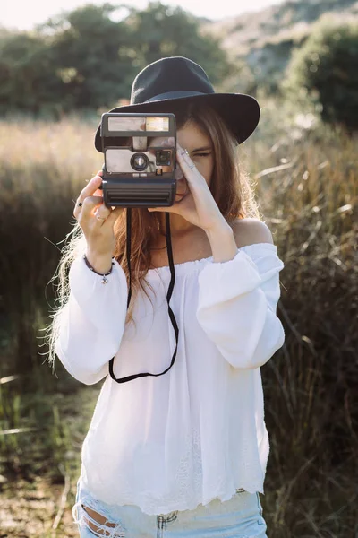 Hipster mujer tomando fotos con una vieja cámara analógica instantánea en —  Fotos de Stock
