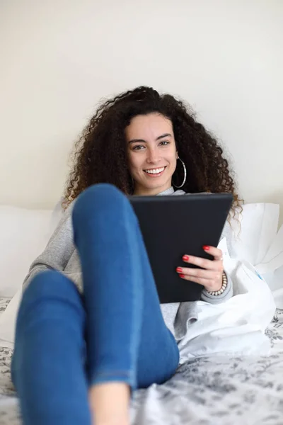 Chica casual leyendo en la tableta digital en la cama — Foto de Stock