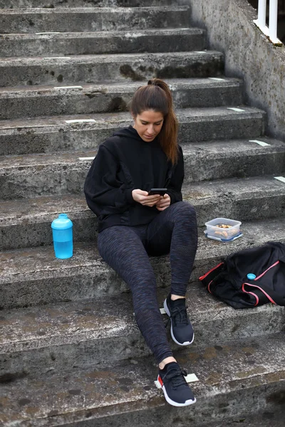 Sporty woman texting on smartphone — Stock Photo, Image
