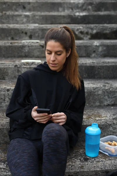 Sporty woman texting on smartphone — Stock Photo, Image