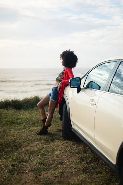 Fashionable afro hairstyle woman getting away with her car — Stock Photo, Image