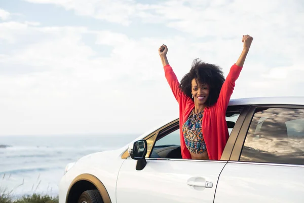 Donna gioiosa nella sua auto godendo la libertà di viaggio su strada verso la costa — Foto Stock