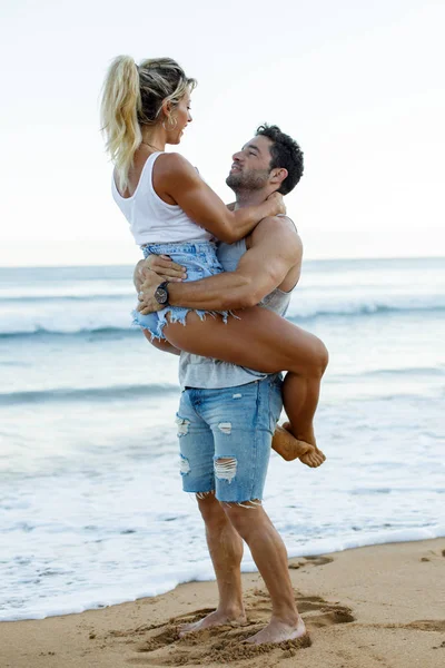 カジュアルな若いカップルがビーチで抱き合って楽しむ — ストック写真