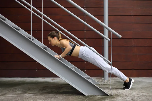 Fit sportif kadın merdivenlerde push up yapıyor — Stok fotoğraf