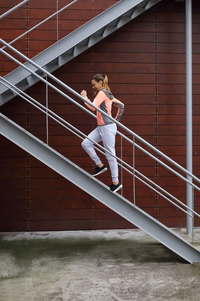 Woman running and climbing stairs in the city — Stock Photo, Image