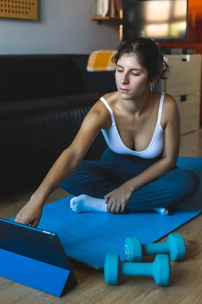Mujer Joven Que Utiliza Tableta Para Seguir Entrenamiento Fitness Clase — Foto de Stock