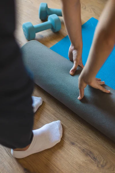 瑜伽室内锻炼过程中 女性在客厅里滚动健身垫的详细情况 积极和健康的生活方式概念 — 图库照片