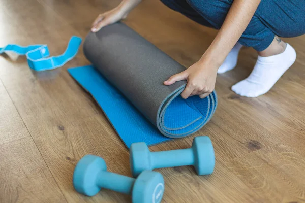 瑜伽室内锻炼过程中 女性在客厅里滚动健身垫的详细情况 积极和健康的生活方式概念 — 图库照片