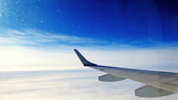 背景に雲と空に飛んでいる飛行機の翼 — ストック写真