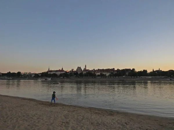 Barn Leker Strand Med Vacker Stadssilhuett Bakgrunden Sett Solnedgången — Stockfoto