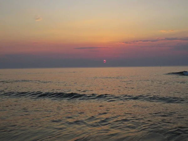 Uma Praia Areia Beira Mar Durante Pôr Sol Com Nuvens — Fotografia de Stock