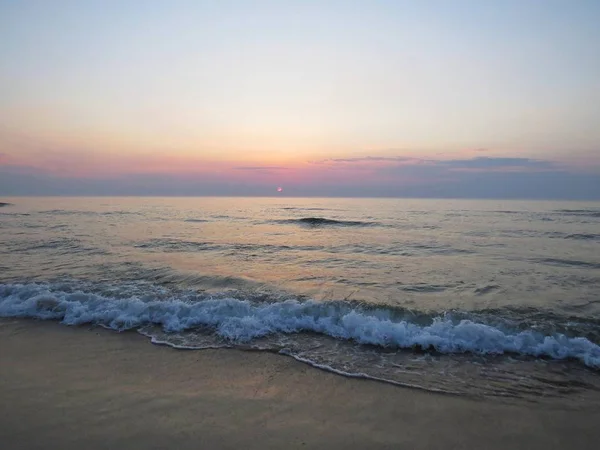 Uma Praia Areia Beira Mar Durante Pôr Sol Com Nuvens — Fotografia de Stock