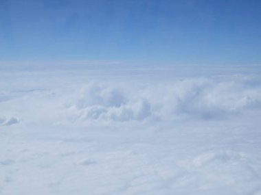 Güzel bir bakış beyaz bulutlar üzerinde mavi gökyüzü, uçak penceresinden