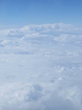 Güzel bir bakış beyaz bulutlar üzerinde mavi gökyüzü, uçak penceresinden