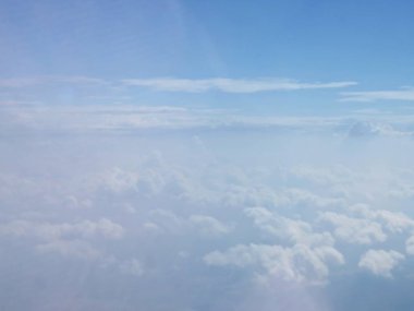 Güzel bir bakış beyaz bulutlar üzerinde mavi gökyüzü, uçak penceresinden