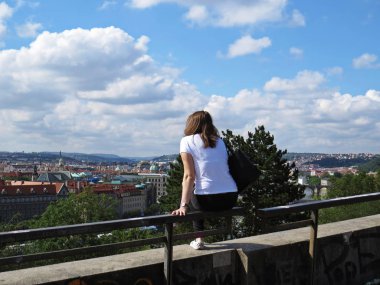 Bir kadın oturma üzerinde duvar korkulan ve zevk rahatlatıcı görünüm içinde güzel tarihi Prag Panorama