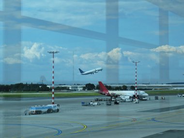 Arka planda başlangıç düzlem ve bulutlu gökyüzü ile Havaalanı koridor Iş terminali Windows