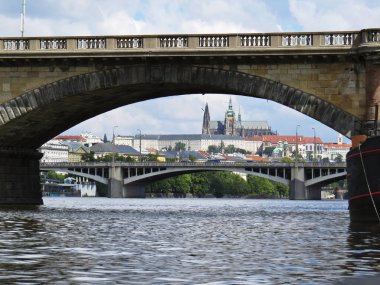 Arka planda bulut gökyüzü ile bir köprü altında seen Prag Kalesi Hradcany Panorama