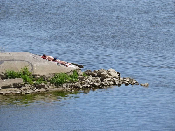 Man Sunbathing and Enjoying Life at a Warsaw Vistula River Bank