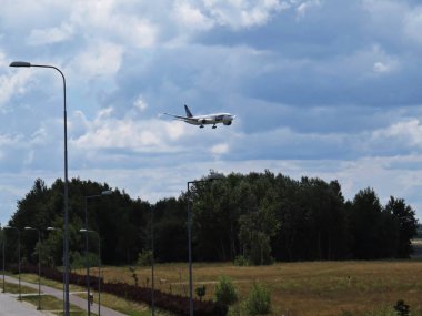 Bir uçan uçak uçak çok Polonya Havayolları ile birlikte bir sokak lambası ve bulutlu gökyüzü, Varşova, Polonya, Temmuz 2018