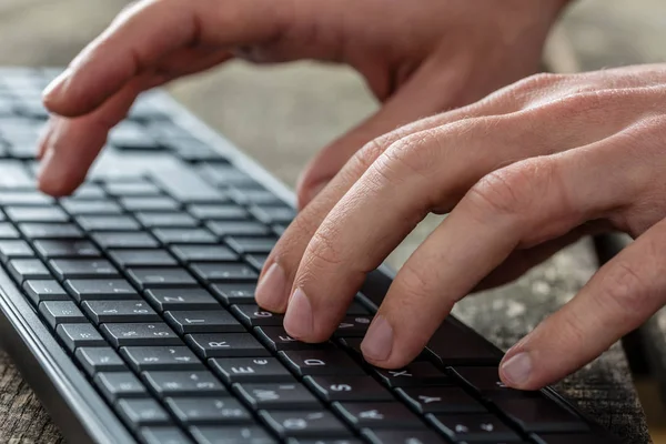 Närbild Händerna Man Att Skriva Ett Svart Tangentbord Som Han — Stockfoto