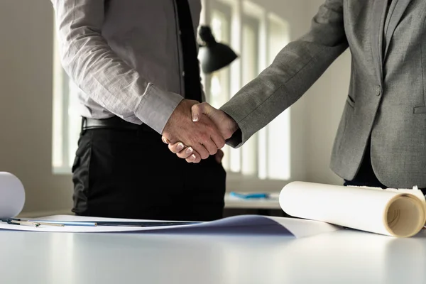 Closeup Male Female Business Partners Shaking Hands Blueprints Office Low — Stock Photo, Image