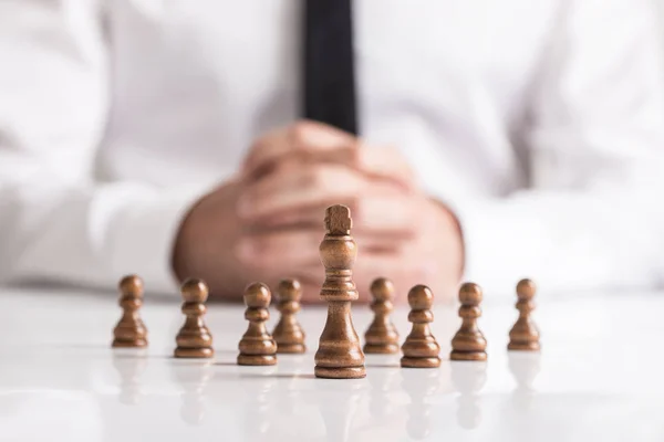 Geschäftsmann Mit Gefalteten Händen Plant Strategie Mit Dunklen Schachfiguren Auf — Stockfoto