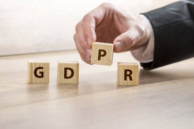 Gdpr kavramı bulunduğu yakın bir takım elbiseli bir işadamı tarafından kadar elinde yerleştirilen yazı ile ahşap oyuncak bloğu kullanma.