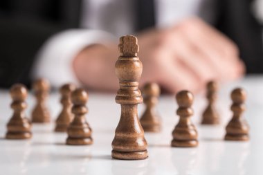 Beyaz masaya işadamı planlama stratejisi ile karanlık satranç figürleri.