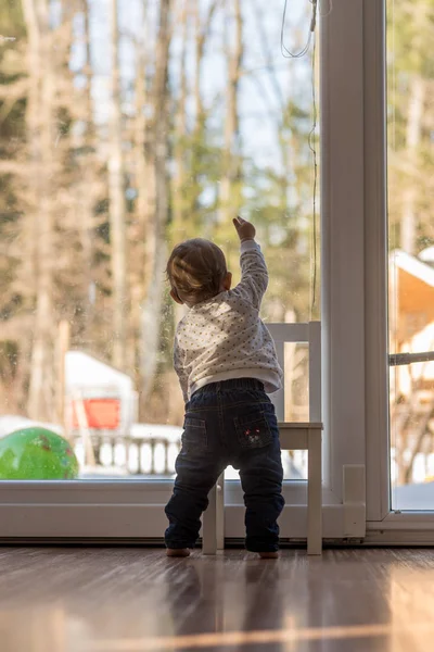 Vista Trasera Niña Mirando Por Una Ventana Casa Con Vistas — Foto de Stock