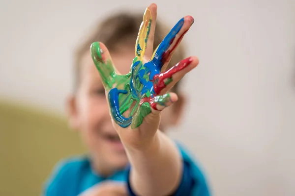 Счастливый Мальчик Рисуя Вручную Протягивает Руку Покрытую Красочной Краской Камере — стоковое фото