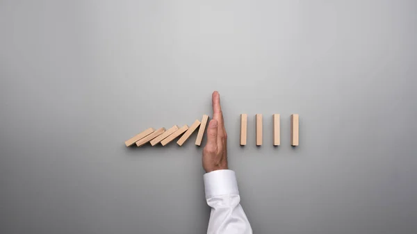 Ovanifrån Manlig Hand Vit Skjorta Stoppa Fallande Dominos Grå Skrivbord — Stockfoto