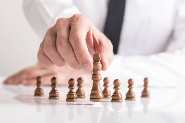Karanlık Kral hareketli işadamı satranç taşını beyaz masada. Kavramsal iş görme.