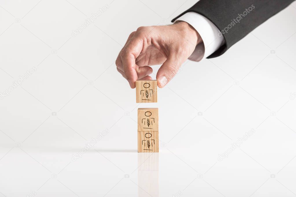 Businessman arranging wooden blocks with human icons - customer-managed relationship Concept against white background.