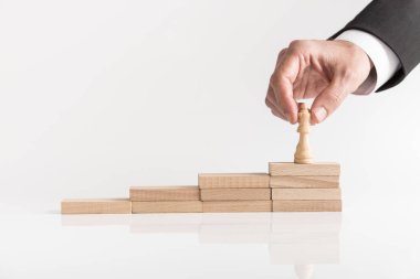 Kraliçe satranç taşını en üst düzeyde ahşap blokların basamaklı bir yığın üzerinde duvar ilanı kavramsal başarı işadamı.