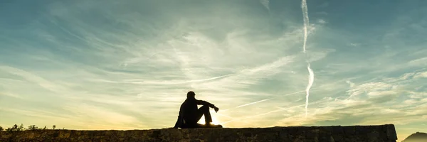 Чоловік Сидить Стіні Спостерігаючи Заходом Сонця Змочений Тлі Барвистого Помаранчевого — стокове фото