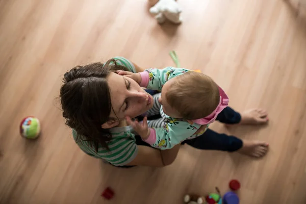 Ovanifrån Ung Mamma Sitter Trägolv Som Leker Med Hennes Lilla — Stockfoto