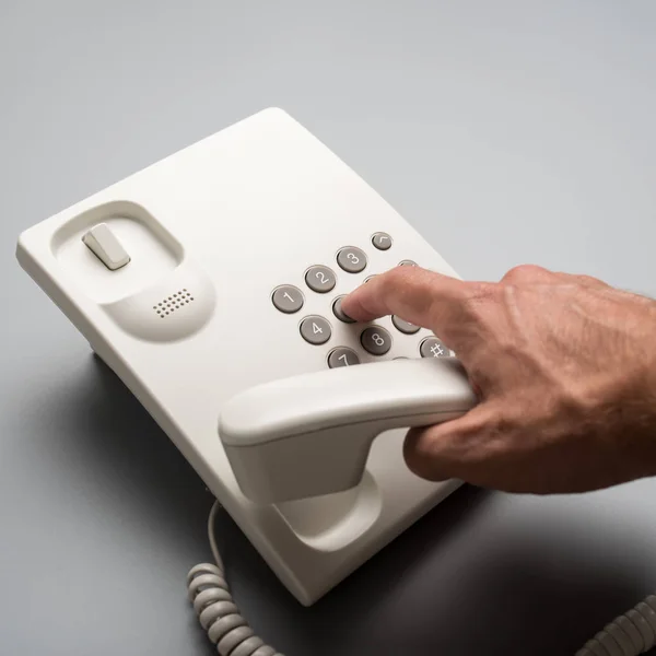 Male Hand Dialing Telephone Number Using White Landline Phone Grey — Stock Photo, Image