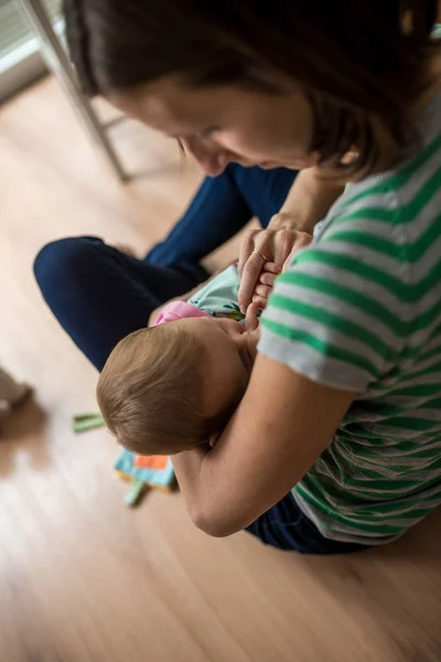 Joven Madre Cariñosamente Abrazando Bebé Mientras Amamanta Sentada Suelo — Foto de Stock
