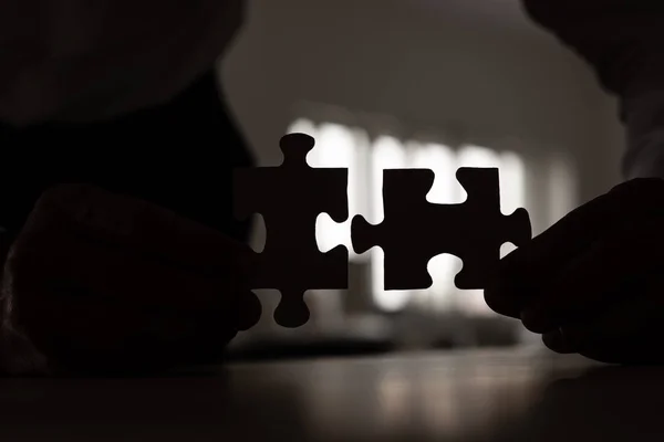Silhouet Van Zakenman Samenstellen Van Twee Overeenkomende Puzzelstukjes — Stockfoto