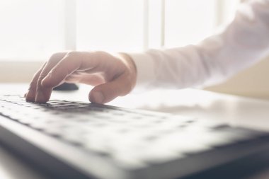 İşadamı el tarafından parlak bir güneş ışığı yaktı office bilgisayar klavye yazarak Retro görüntü.